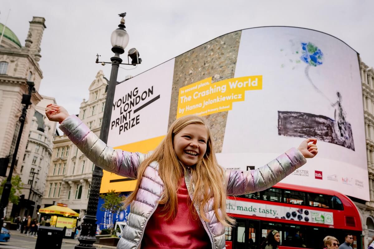 Runner-up Hanna Jelonkiewicz celebrating her winning print being displayed on the giant screen in Piccadilly Circus.
