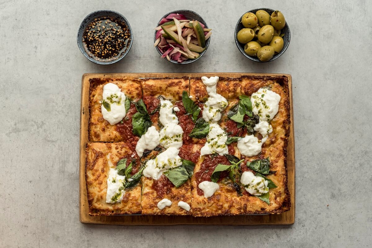 The OG Pizza, a homage to the classic margarita and a selection of sides: Smoked maple chilli, olives and chef's pickles.