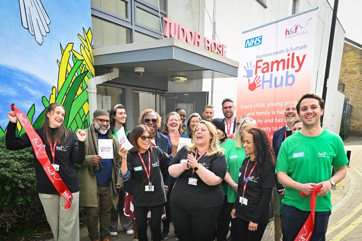 Cllr Alex Sanderson (centre right) with H&F staff and partners, and Cllr Sharon Holder (second row, centre left) cut the hub's ribbon