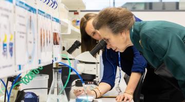 Princess Anne (front) looking at fruit flies with post doctoral researcher Claudia Lennicke (back)