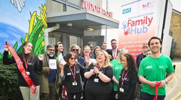 Cllr Alex Sanderson (centre right) with H&F staff and partners, and Cllr Sharon Holder (second row, centre left) cut the hub's ribbon