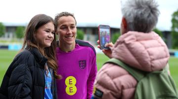 Lucy Bronze poses for a photo with a fan at the end of England's training session