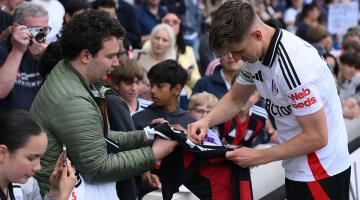 Tom Cairney signs an autograph for a fan