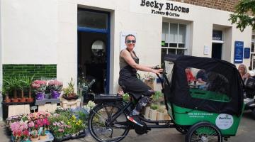 Woman on an cargo e-bike smiling to the camera