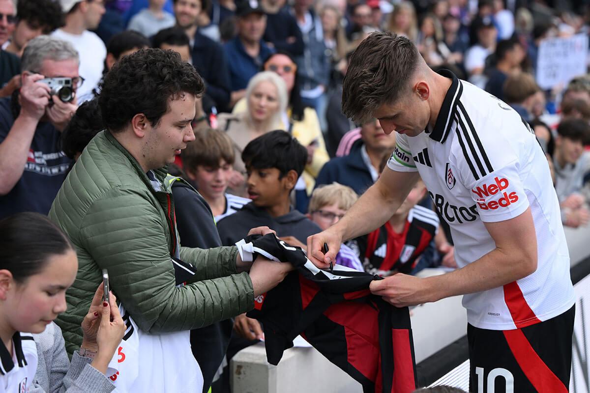 Tom Cairney signs an autograph for a fan