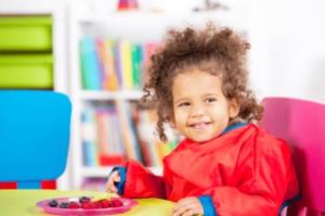 Smiling child sitting at a table.