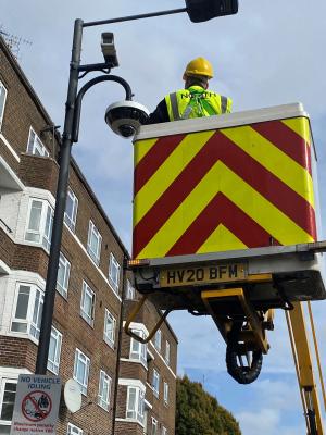 CCTV camera installation in progress, showing a construction worker on a lift working on a CCTV camera on a streetlight