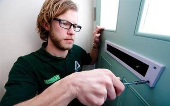 Green Doctor fitting a letterbox draught excluder