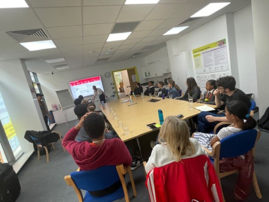 Young people from youth council sitting around a big table discussing the LO