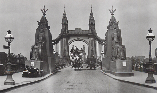 Black and white photo of a horse and cart crossing Hammersmith Bridge