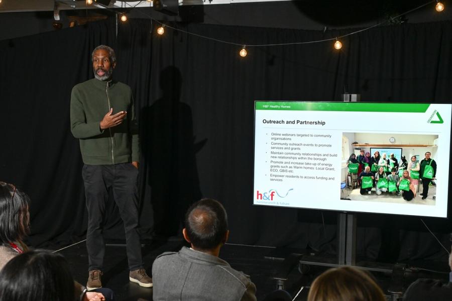 A man standing in front of a screen presenting to an audience.