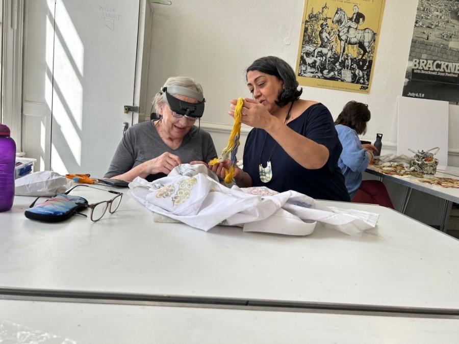 Amarjeet (right) demonstrating hand stitching techniques