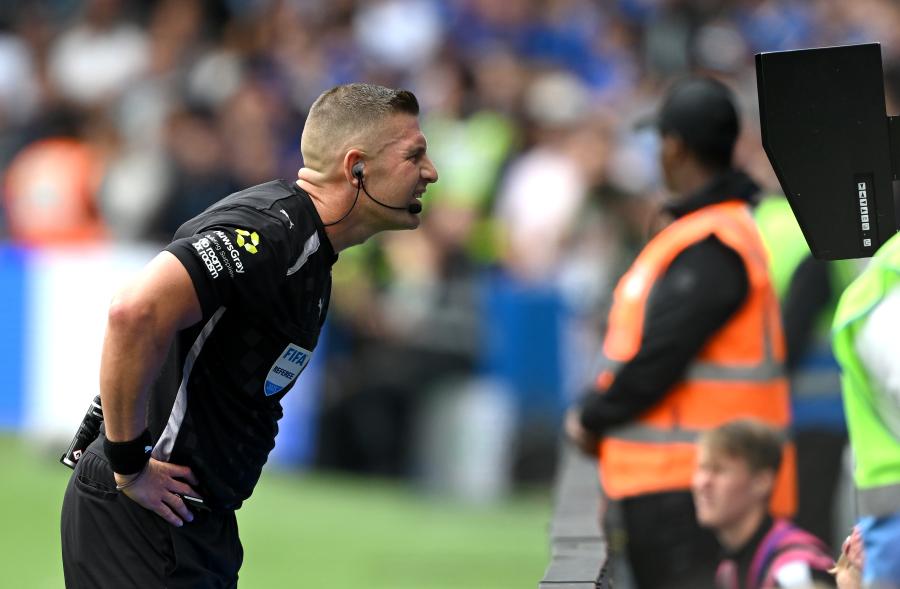 Referee Robert Jones checks the VAR screen after Fulham's disallowed goal
