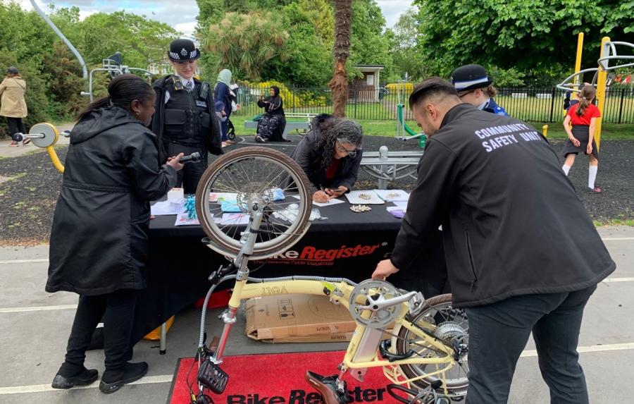 Members of the community safety team running a bike registration stall in a park in H&amp;F