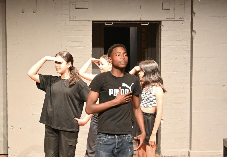 Four young people performing in a circle, facing different directions